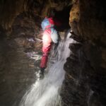 Scrambling down the waterfall in Swildon's Hole cave, the Mendips